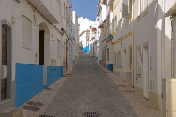 Rua estreita em um bairro antigo com edifícios brancos durante o dia — Fotografia de Stock