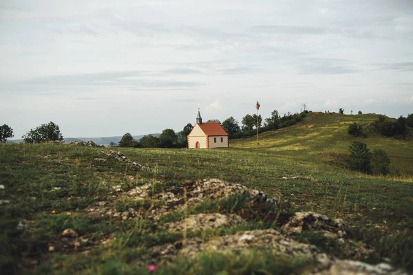 Piękny Widok Domku Trawie Pokryte Pole Pod Zachmurzonym Niebem — Zdjęcie stockowe