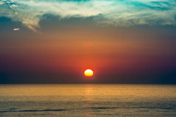 Eine Schöne Aufnahme Des Meeres Mit Einer Roten Sonne Hintergrund — Stockfoto