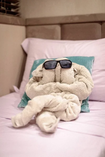 A funny towel folding with glasses on the bed for kids' cabin