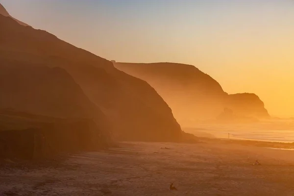 Landscape of mountain silhouettes surrounded by the beach during sunset in Portugal Algarve — Stock Photo, Image