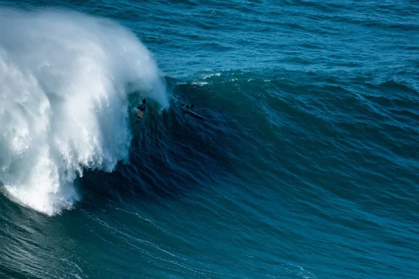 Alta ola espumosa del Océano Atlántico llevando a los surfistas hacia la orilla del Nazare, Portugal —  Fotos de Stock