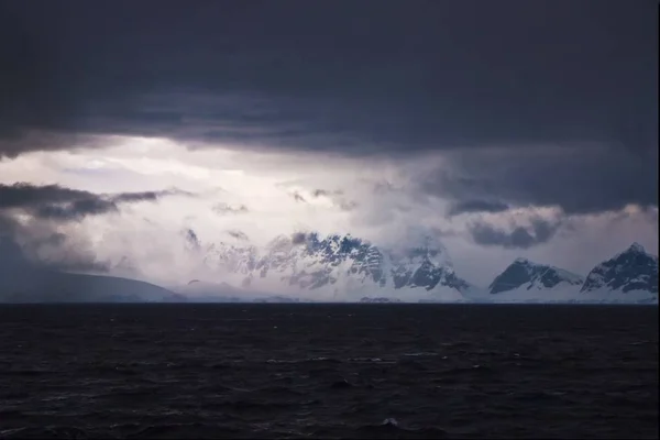 Paesaggio dell'oceano circondato dal ghiaccio in Antartide sotto un cielo buio e nuvoloso — Foto Stock