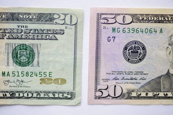 在白色的表面上拍了一张五十美元和二十美元钞票的特写 — 图库照片