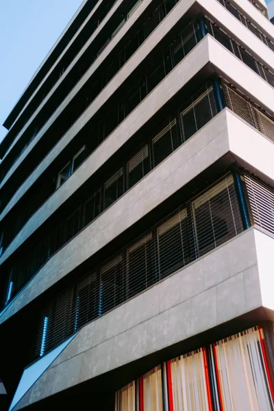 Tiro vertical de ângulo baixo de uma pedra e construção de metal sob o céu azul — Fotografia de Stock