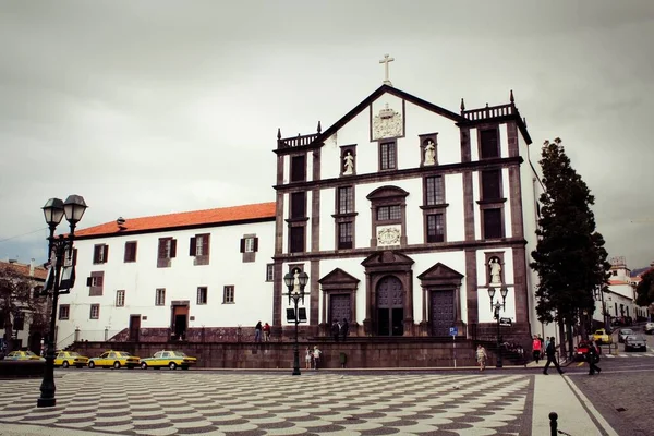 Portekiz 'deki Maderia Adası' nda bulutlu bir gökyüzünün altında yürüyen insanların olduğu bir kilise resmi. — Stok fotoğraf