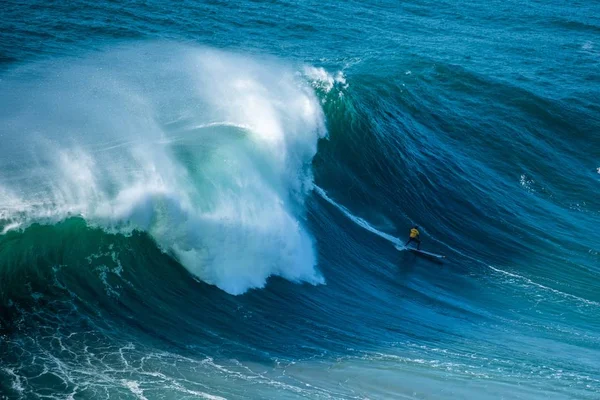 Surfista navegando a través de las olas espumosas del Océano Atlántico hacia la orilla del Nazare, Portugal — Foto de Stock