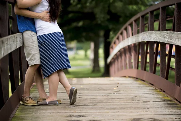 Shallow focus shot of a couple kissing each other on a wooden bridge — 스톡 사진