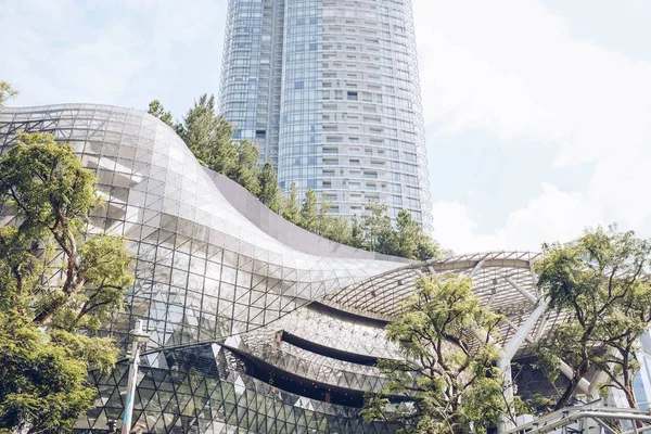 Hermoso edificio de vidrio y una torre de vidrio bajo el cielo nublado capturado en Singapur — Foto de Stock