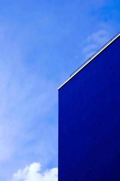 Tiro vertical de um edifício azul com o céu azul no fundo — Fotografia de Stock