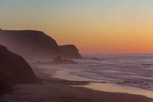 Bela imagem do mar coberto de nevoeiro rodeado de rochas durante o pôr-do-sol em Portugal, Algarve — Fotografia de Stock