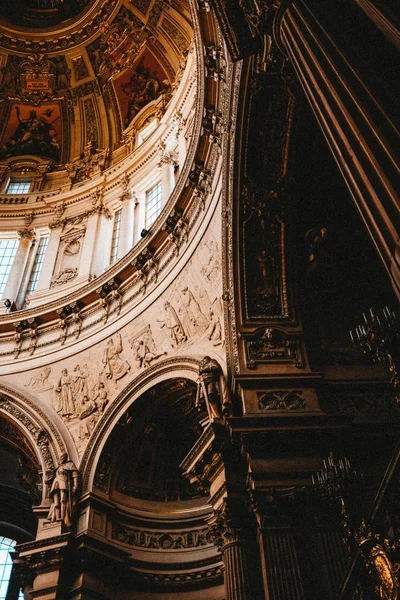 Vertical low angle shot of the beautiful paintings and carvings in an old building — ストック写真