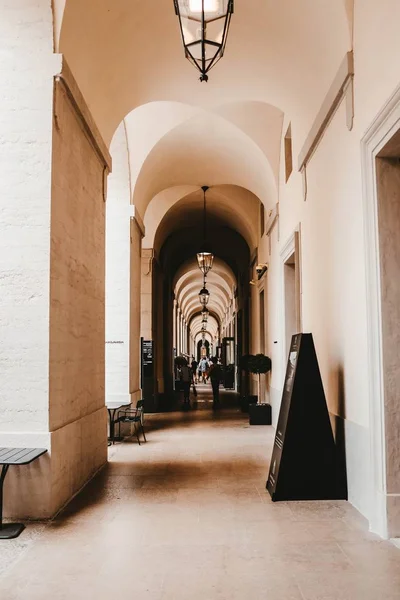 Scatto verticale di un corridoio con pareti bianche e vecchi lampadari sul soffitto — Foto Stock