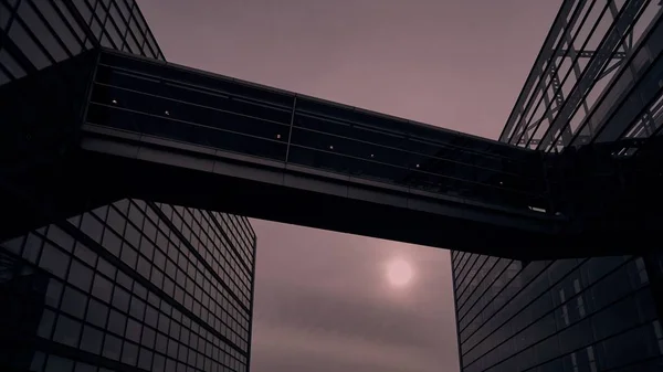 Vista de baixo ângulo de um edifício moderno com paredes de vidro sob um céu nublado durante o pôr do sol — Fotografia de Stock