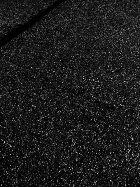 Vertical grey scale shot of the asphalt on the street — Stock Photo, Image