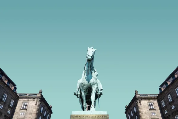 Flachbild einer Pferdestatue zwischen den Gebäuden unter blauem Himmel — Stockfoto