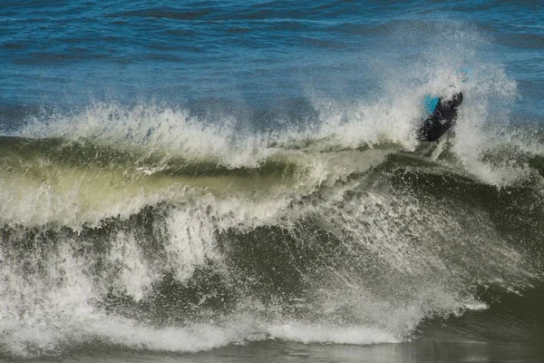 Surfer menghadapi gelombang air hijau dari Samudera Atlantik dekat Nazare, Portugal — Stok Foto