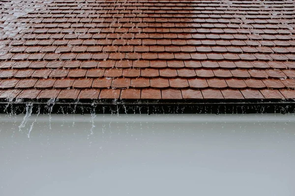 Tiro de close-up vertical de um telhado marrom sob a chuva pesada — Fotografia de Stock