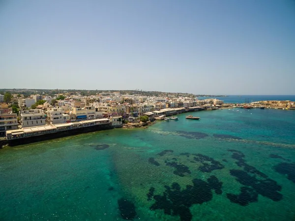 Tiro de ângulo alto dos edifícios pelo mar bonito calmo capturado em Creta, Greece — Fotografia de Stock