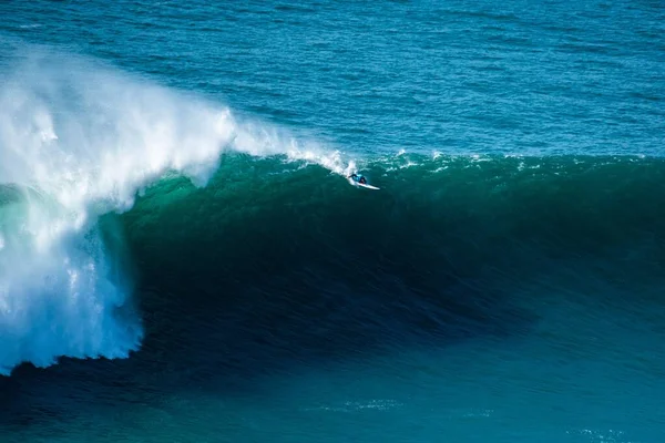Lange schuimgolf van de Atlantische Oceaan die de surfer naar de kust van Nazare, Portugal, brengt — Stockfoto