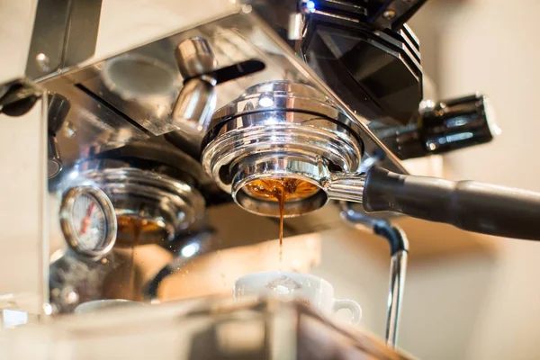 Silver coffee making machine filling coffee in a white ceramic cup — Stock Photo, Image