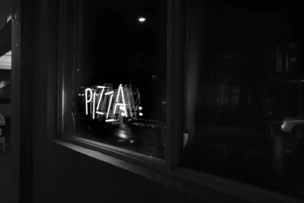 Scatto in scala di grigi delle finestre di una pizzeria scura catturata a Portland, Stati Uniti — Foto Stock