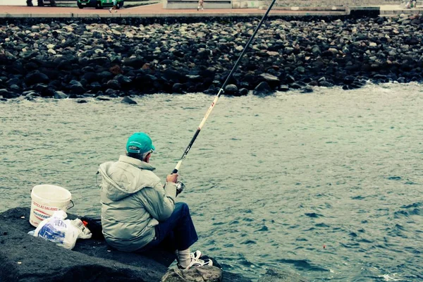 Pescador sozinho sentado em um peixe de captura de pedra em Palma, na Espanha — Fotografia de Stock