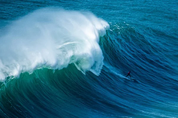 Onda espumosa alta do Oceano Atlântico que leva o surfista para a costa de Nazare, Portugal — Fotografia de Stock