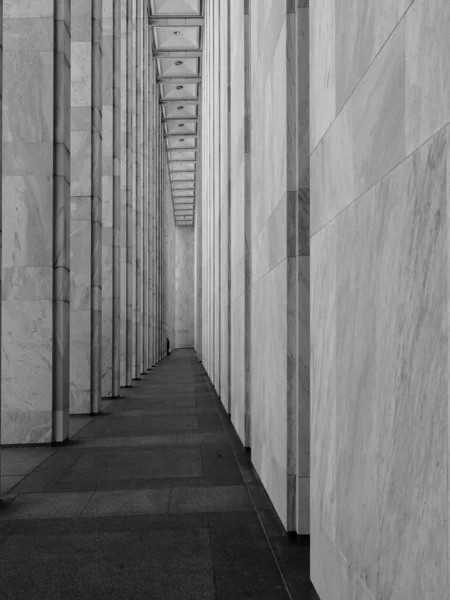 Eine Vertikale Graustufenaufnahme Eines Langen Korridors Mit Säulen Und Weißen — Stockfoto