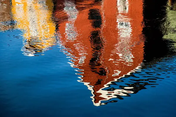 Красное и желтое здание, отражающееся в озере - отлично подходит для заднего плана — стоковое фото
