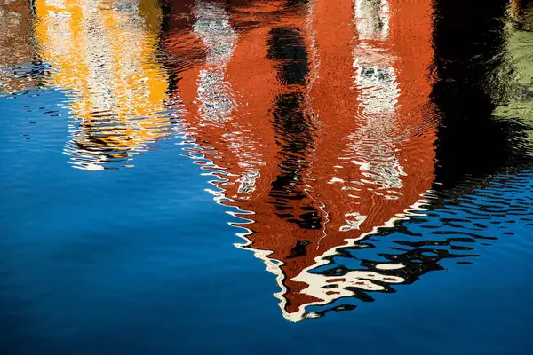 Edifício vermelho e amarelo refletindo no lago - ótimo para um fundo — Fotografia de Stock