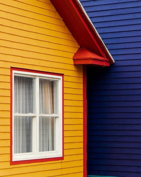 Plan vertical d'une maison en bois peinte en jaune, rouge et bleu — Photo