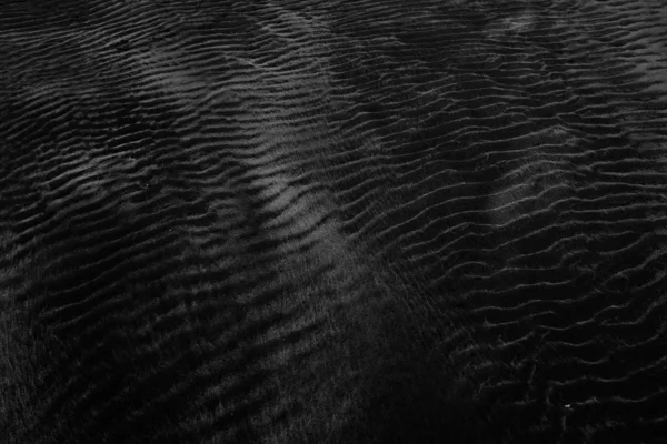 Closeup shot of wet black sand perfect for using a neutral background — Stock Photo, Image