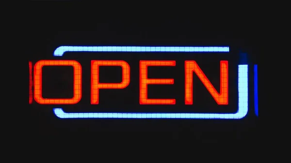 Closeup shot of an Open sign lighting up its surroundings in the middle of the night — Stock Photo, Image