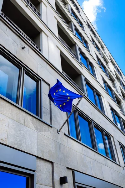 Plan vertical à angle bas d'un bâtiment d'affaires moderne avec le drapeau de l'Europe attaché — Photo