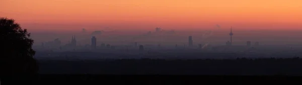 Gün batımı gökyüzünün altında sisle kaplanmış şehir manzarasının güzel panoramik görüntüsü. — Stok fotoğraf