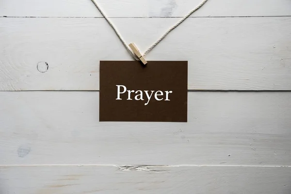 Primo piano di un segno attaccato ad una corda con la preghiera scritta su di esso — Foto Stock