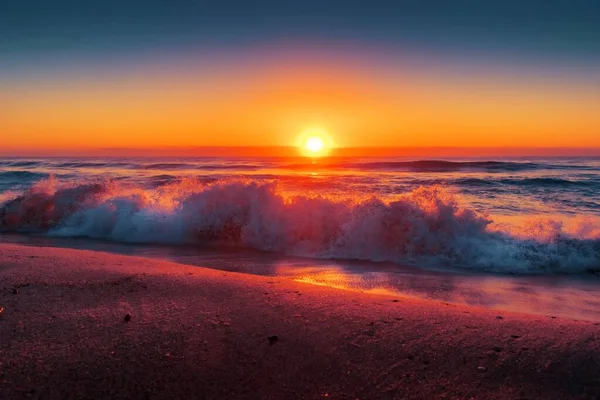 Hermosa vista de las olas del océano bajo el hermoso atardecer en el cielo colorido — Foto de Stock