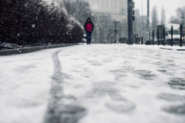 Niski kąt strzału osoby chodzącej po pokrytym śniegiem chodniku pod śniegiem — Zdjęcie stockowe