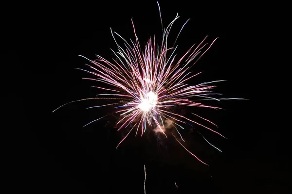 Belo tiro de fogos de artifício estourando no céu noturno espalhando uma atmosfera festiva — Fotografia de Stock