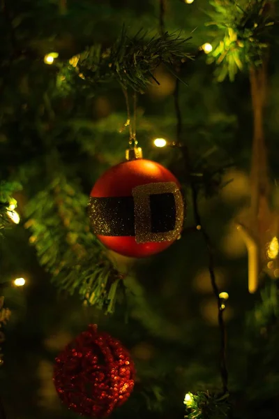 Tiro vertical de um ornamento de Natal pendurado em uma árvore que espalha uma atmosfera festiva — Fotografia de Stock