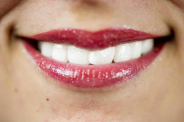 Foto de cierre de una hembra sonriente con un palo de labios rojos. —  Fotos de Stock