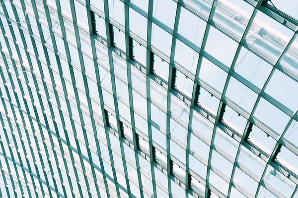 Χαμηλή γωνία βολής των παραθύρων σε ένα γυάλινο κτίριο που αντανακλά τον γαλάζιο ουρανό — Φωτογραφία Αρχείου