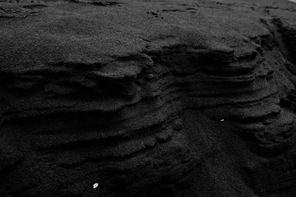 Closeup tiro de areia preta em uma formação de rocha perfeita para fundo minimalista — Fotografia de Stock