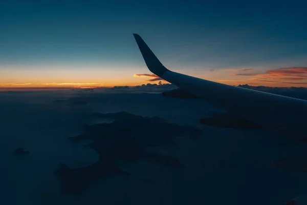 Mooie zonsondergang vanbinnen in een vliegtuig en de vleugel zichtbaar — Stockfoto