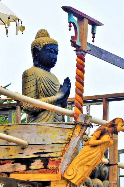 Vertical low angle shot of a religious statue surrounded by other objects under the clear sky — Stock Photo, Image