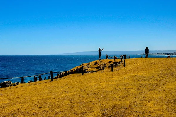 Krásný záběr lidí stojících na pobřeží oceánu za větrného letního dne — Stock fotografie