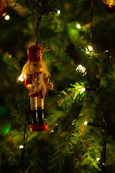 Tiro vertical de um ornamento de Natal pendurado em uma árvore que espalha uma atmosfera festiva — Fotografia de Stock