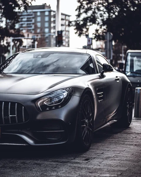 Verticale close-up shot van een glanzende zwarte luxe auto in het midden van een straat — Stockfoto