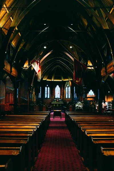 Vertikale Aufnahme einer Kirche mit Holzbänken und religiöser Atmosphäre — Stockfoto
